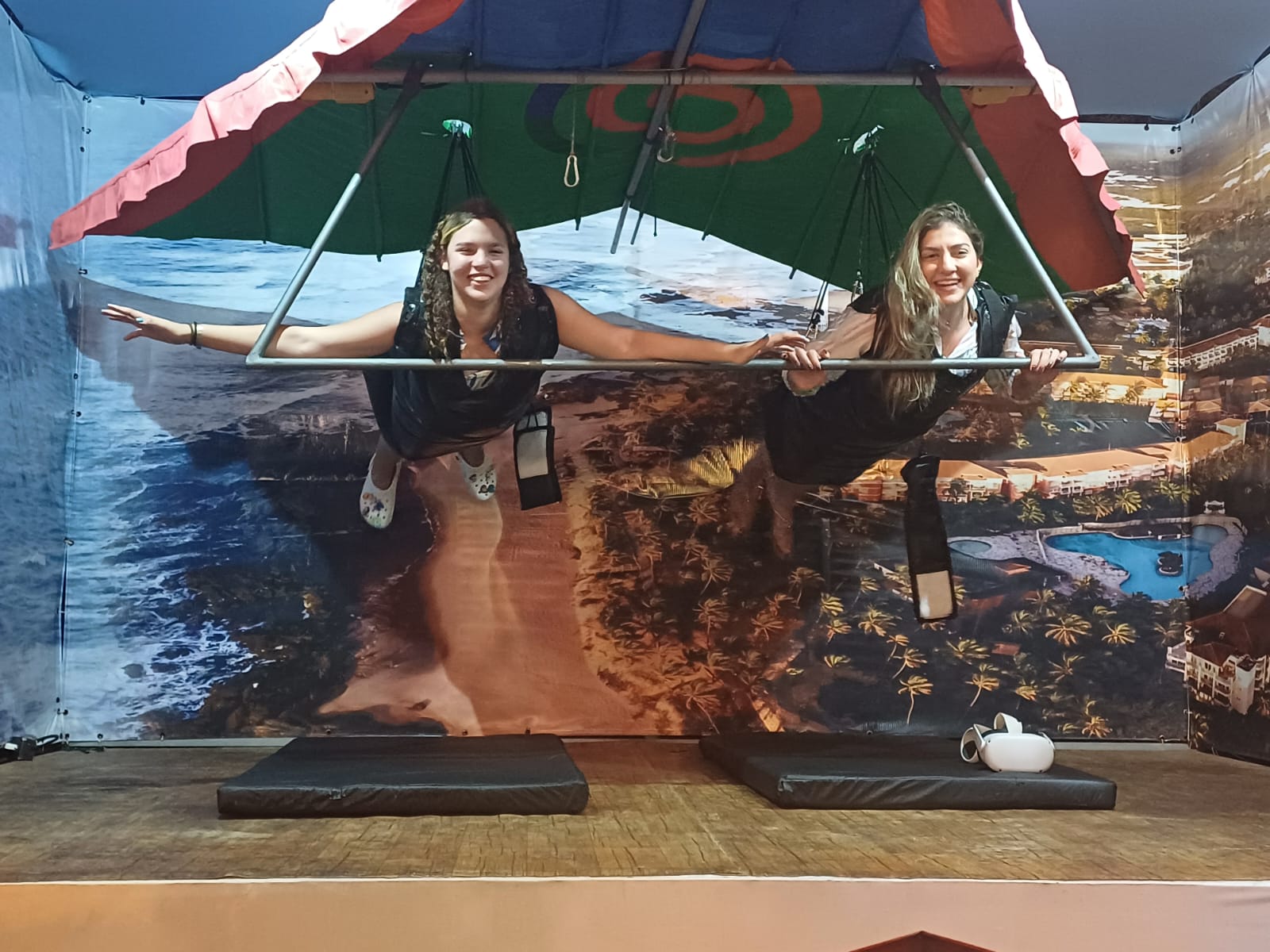 Duas pessoas sorrindo em simulação de voo indoor.